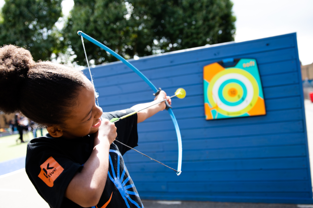 Image of young girl firing an arrow at target
